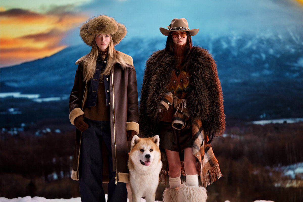 Models wearing Goldbergh's Fall/Winter 2026-2027 collection in front of a Niseko mountain backdrop with an Akita dog