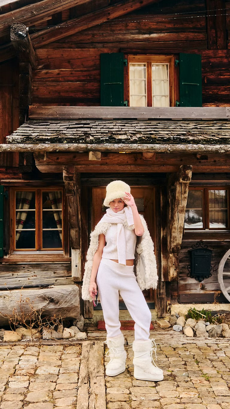 Perfect Moment cream knitwear and shearling styled at an alpine chalet, AW26